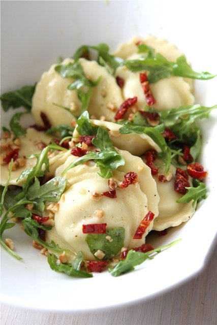 Raviolis rápidos con tomates secados al sol, rúcula y avellanas