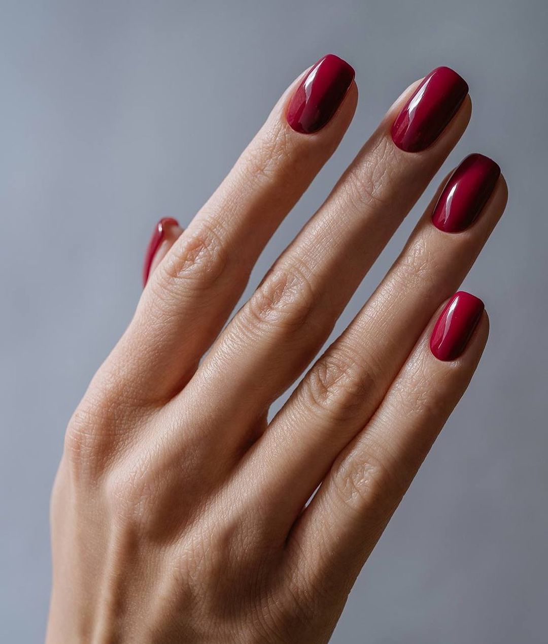 Female Hands With Long Nails And Neon Coral Orange Nail Polish